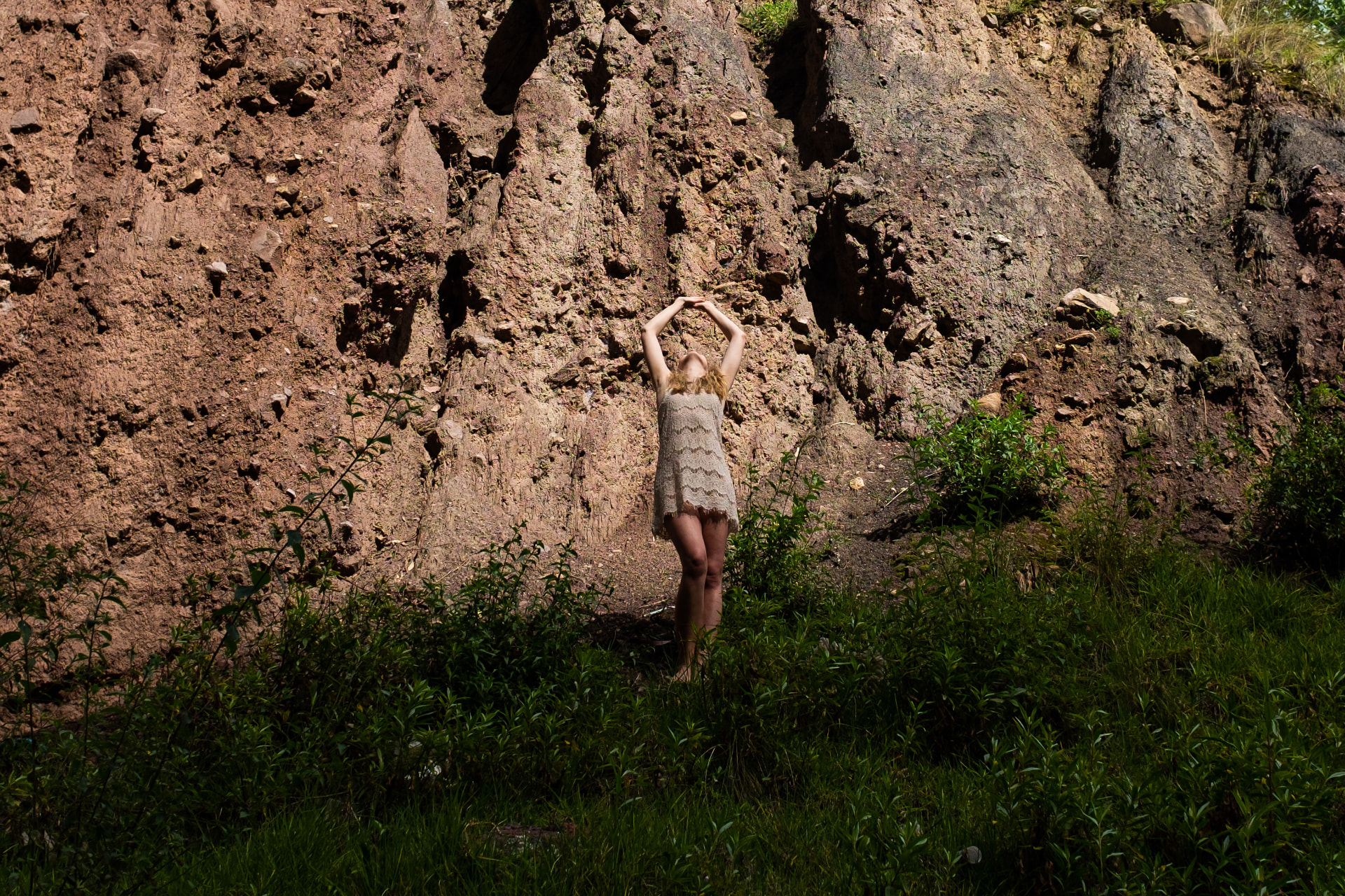 Ann-Sophie vor einer Lehmwand in einer Yoga-Pose